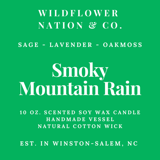 A bright green square label with white text reading 'WILDFLOWER NATION & CO.' and 'Smoky Mountain Rain,' plus scent notes 'SAGE - LAVENDER - OAKMOSS' and product details for a 10 oz.